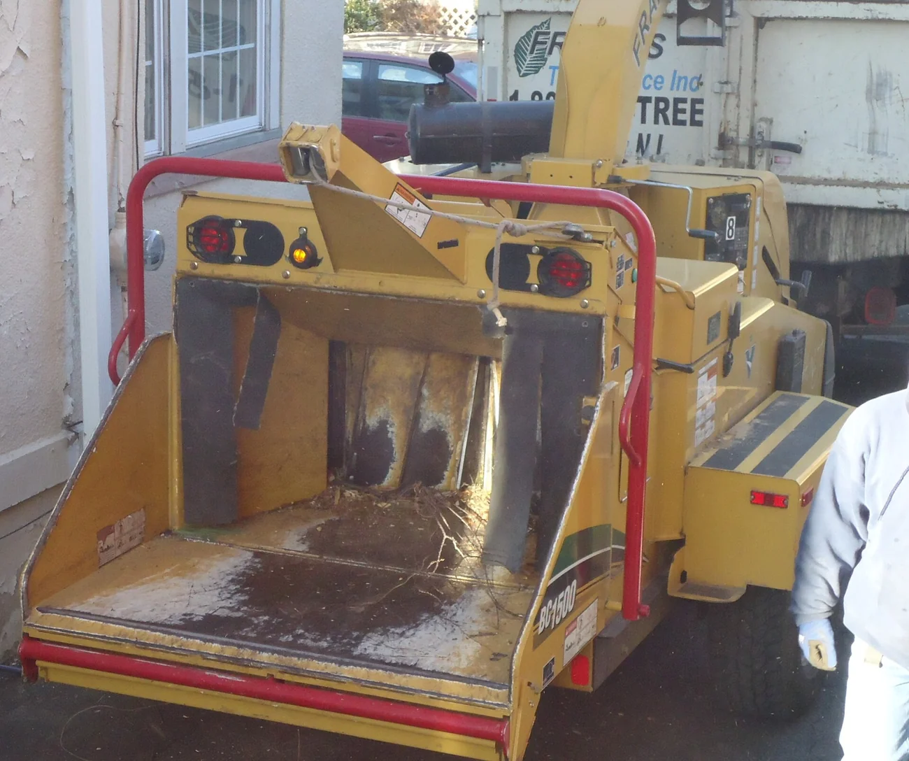 The feed chute of a wood chipper mounted behind a truck